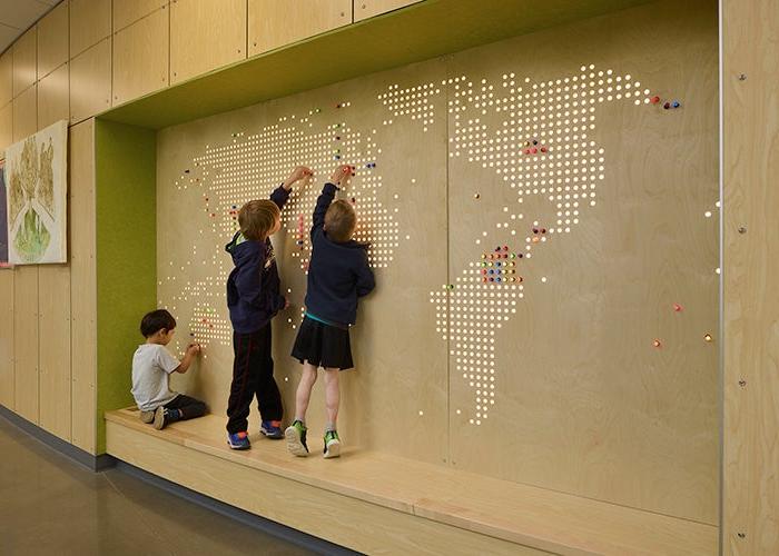 children in a nook in front of a map